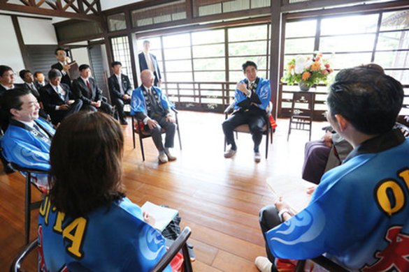 Japan Prime Minister speaks with workers.