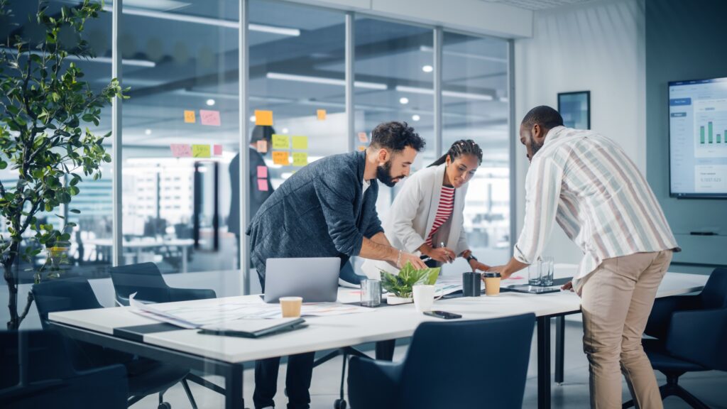 Diverse Team of Professional Businesspeople Meeting in the Office Conference Room Creative Team Around Table, Black Businesswoman, African American Digital Entrepreneur and Hispanic CEO Talking